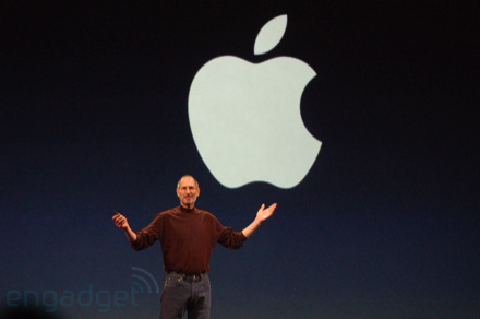 Steve Jobs in front of a large Apple logo