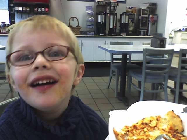 Picture of a little boy at a diner with food all over his mouth.