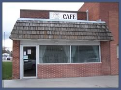 A small brick diner with a sign that says CAFÉ.