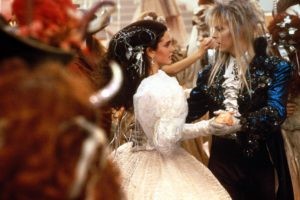 An image of Jennifer Connelly (Sarah) and David Bowie (Jareth the Goblin King) in formal 18th-century-ish formal clothes waltzing.
