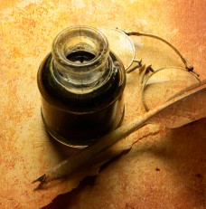 18th-century inkwell, spectacles, and feather pen on aged parchment.