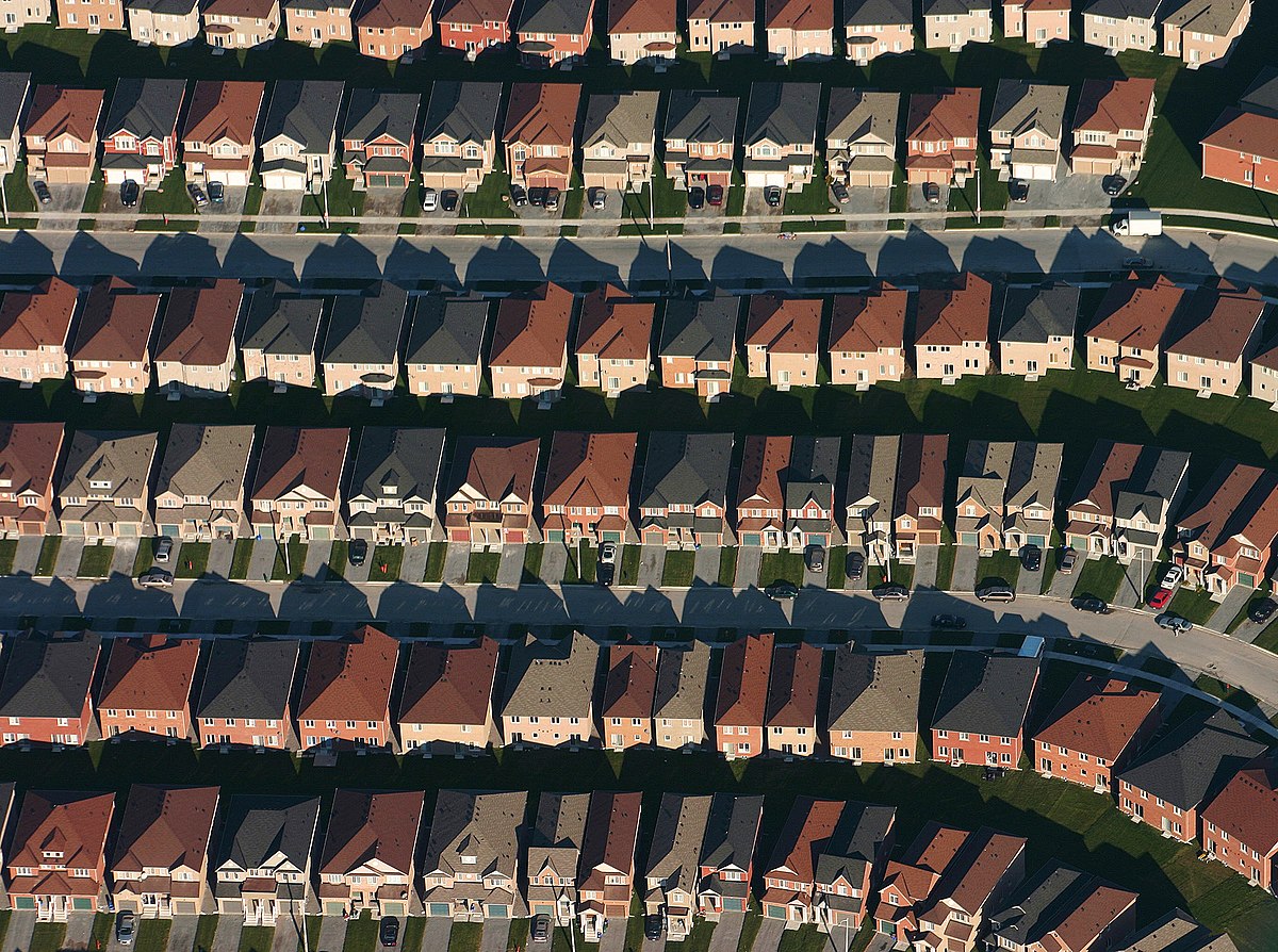 An overhead shot of a neighborhood of tract housing, with all houses spaced close together.